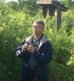 肯安川在田野里观察鸟类.